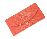Red clutch bag with textured surface on a white background